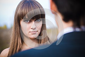 Woman looking seriously over man shoulder