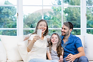 Woman looking at smart phone while sitting with family