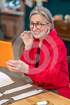 Woman looking at smartphone sitting at table with patterns