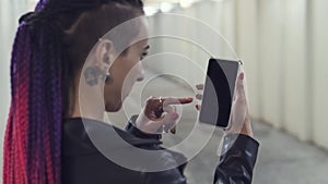 Woman looking smartphone. young beautiful girl with a non-standard appearance listens to music on the phone. rocker rockandro