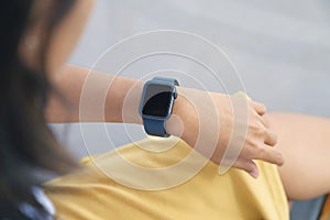 A woman looking at smartwatch on hand