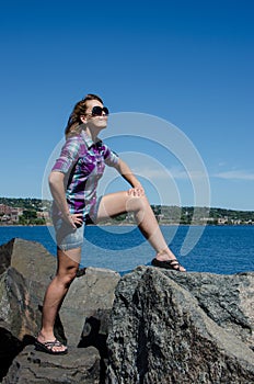 Woman looking smug and happy poses on rocks at the lakewalk in Canal Park Duluth MN