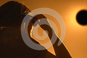 Woman is looking on solar eclipse through three sunglasses.