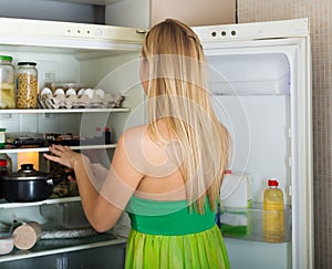 Woman looking for something in refrigerator