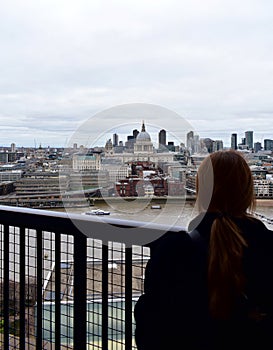 Woman looking at St Pauls Cathedral from Tate Modern lookout. London, United Kingdom. photo