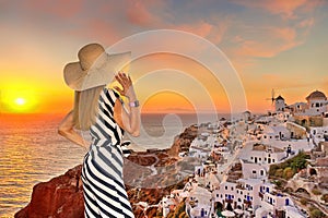 A woman looking the sunset of Oia in Santorini, Greece