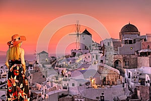 A woman looking the sunset of Oia in Santorini, Greece