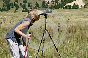 Woman looking thru a spotting scope