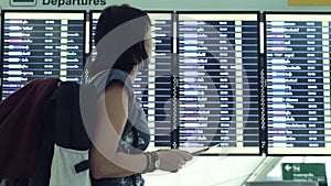 Woman Looking At Timetable Departure Board at airport