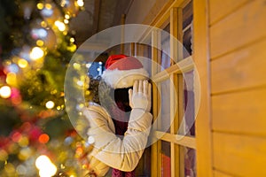 Woman looking to house window at christmas market