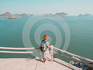 Woman looking at unique view of Halong Bay, Vietnam. Tourist walking on promenade at Cat Ba island among Ha Long Bay rock