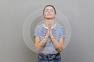 Woman looking up with imploring desperate grimace, praying to god asking for help.