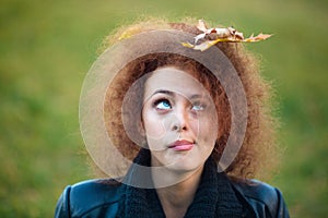 Woman looking up on leave in her curly hair