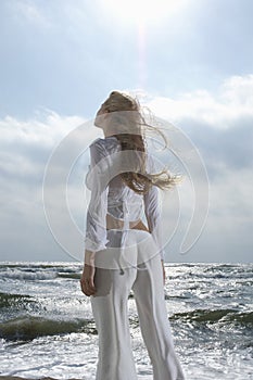 Woman Looking Up At Sky Against Ocean