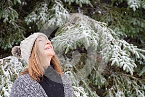 Woman looking up at snow falling