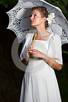 Woman looking upwards white dress lace umbrella