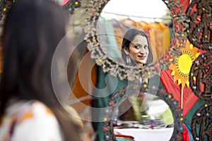 Woman looking into vintage mirror at Surajkund Mela photo