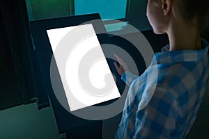 Woman using interactive white empty touchscreen display kiosk at exhibition