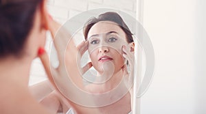 Woman looking at wrinkles in mirror. Plastic surgery and collage
