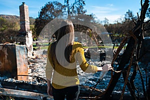 Woman lookinh at her burned home after fire disaster