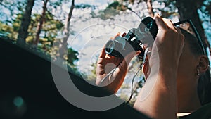 Woman Looks Through Binoculars on a Chaise Longue in a Forest near Camping