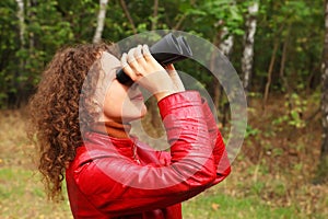 Woman looks through binoculars outside