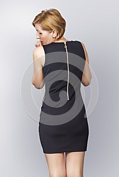 The woman looks cautiously over her shoulder checking her hips