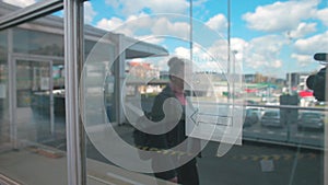 A woman looks at a COVID-19 sign behind glass. Precautionary measures