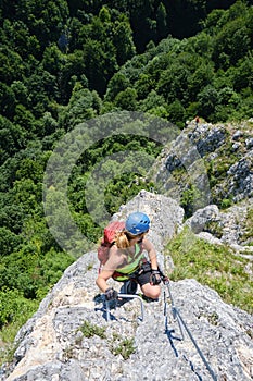 Woman looks down on the via ferrata called Soim Calator, above Varghis gorges, Persani mountains, Romania. Summer activities.