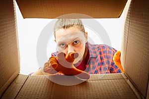 A woman looks into the empty box from the inside.photo of a woman peering into a box