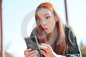 Woman looks with great amazement at what she has just seen on her smartphone