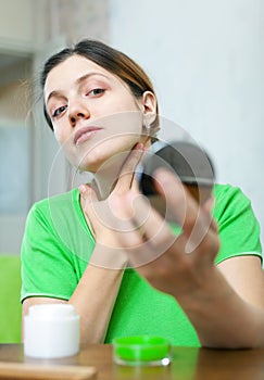 Woman looks on her skin