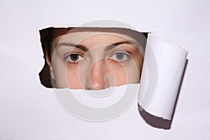 Woman looks in hole of sheet of paper