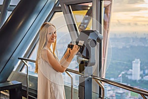 Woman looks at Kuala lumpur cityscape. Panoramic view of Kuala Lumpur city skyline evening at sunset skyscrapers