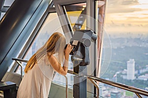 Woman looks at Kuala lumpur cityscape. Panoramic view of Kuala Lumpur city skyline evening at sunset skyscrapers