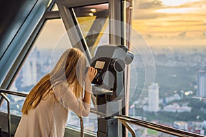 Woman looks at Kuala lumpur cityscape. Panoramic view of Kuala Lumpur city skyline evening at sunset skyscrapers