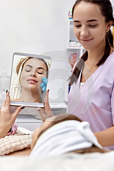 woman looks at mirror after procedure lip augmentation