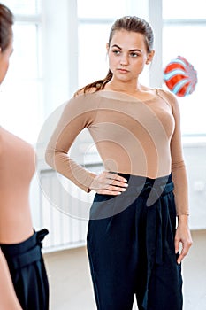 Woman looks in the mirror trying on pants