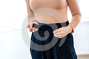 Woman looks in the mirror trying on pants