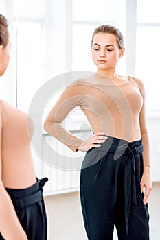 Woman looks in the mirror trying on pants