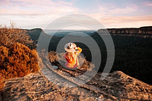 Woman looks out over the mountains in the late afternoon sun