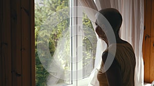 a woman looks out of the window into the courtyard