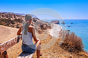 Woman looks on panoramic landscape Petra tou Romiou The rock of the Greek, Aphrodite`s legendary birthplace in Paphos, Cyprus