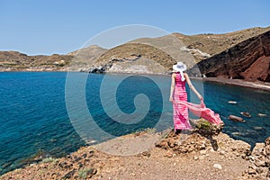 Woman looks at the red beach in Santorini, Greece