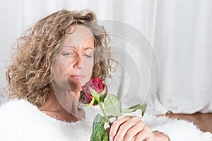 Woman looks at rose