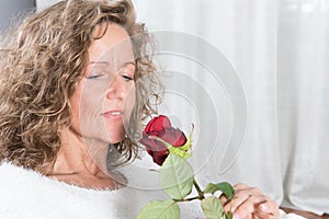 Woman looks at rose