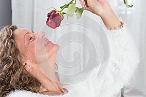 Woman looks at rose