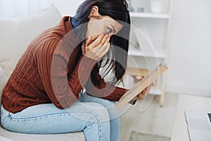 The woman looks sadly at the picture frames in her hands and with memories, a state of depression and loss of a person