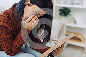 The woman looks sadly at the picture frames in her hands and with memories, a state of depression and loss of a person