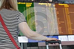 Woman looks at the scoreboard at the airport. Select a country Ireland for travel or migration